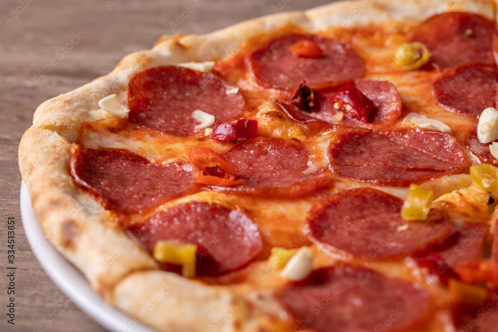 fresh tasty salami pizza on a wooden background fresh tasty salami pizza on a wooden background