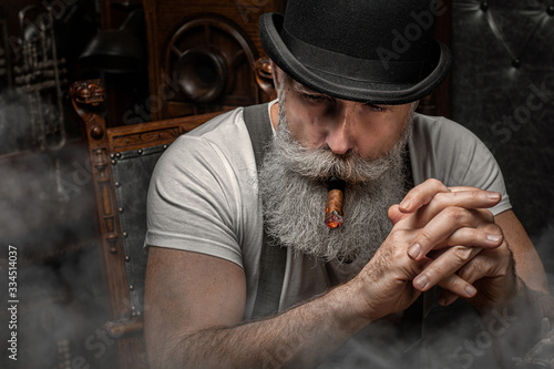 фотография Old man smoking a cigar indoors