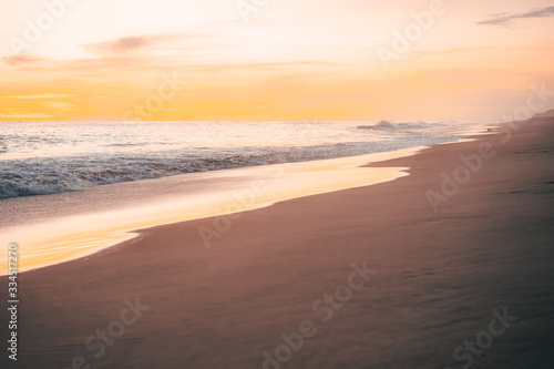 Pacific waves and sandy beach at sunset