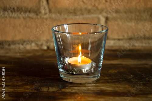 candle lit inside a glass with pine cone