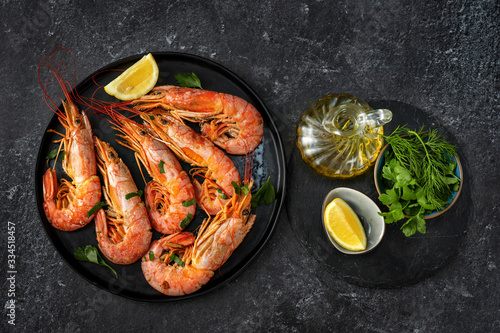 Top view of dining table with red big prawns and coocking ingredients photo