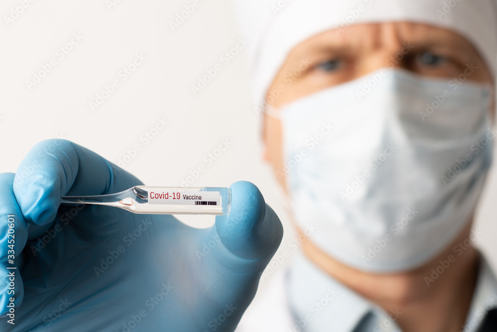 Doctor holds ampule with coronavirus vaccine. Scientists created vaccine to stop Covid-19 pandemic Doctor holds ampule with coronavirus vaccine. Scientists created vaccine to stop Covid-19 pandemic