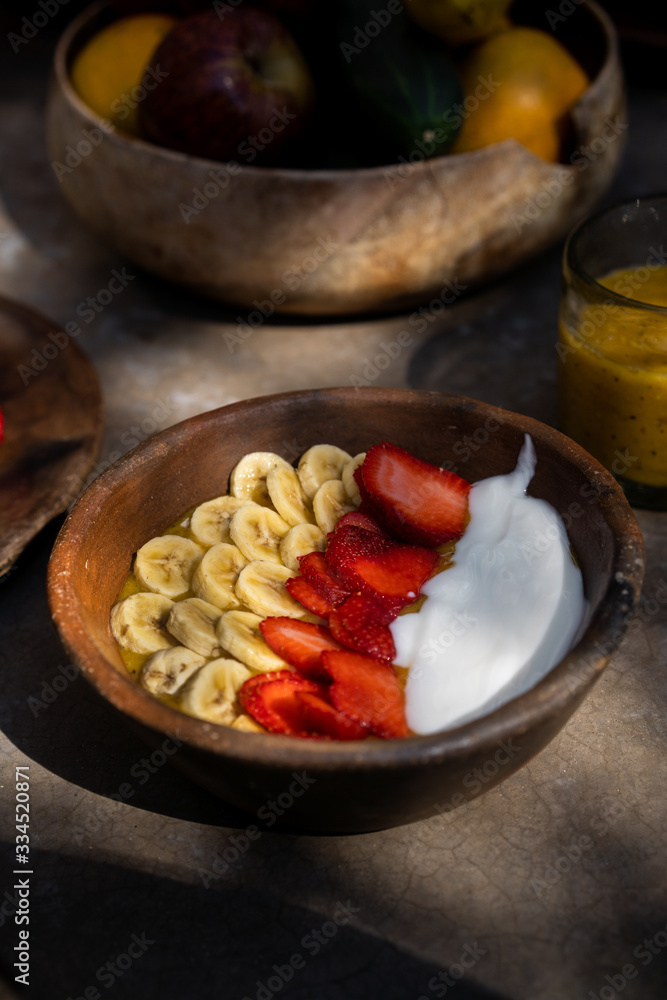 Smoothie bowls with bananas and strawberries in wooden plates