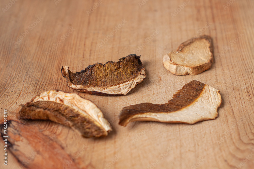 Dried edible white mushrooms on wooden background in rustic style. Superfood trend, healthy food ingredients. Dry fungi dishes vegetarian, vegan recipes.Natural wild forest fungus nutritional benefits Dried edible white mushrooms on wooden background in rustic style. Superfood trend, healthy food ingredients. Dry fungi dishes vegetarian, vegan recipes.Natural wild forest fungus nutritional benefits
