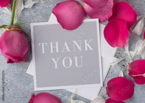 Fancy Greeting card to express thanks with posh red rrose petals from above as a background