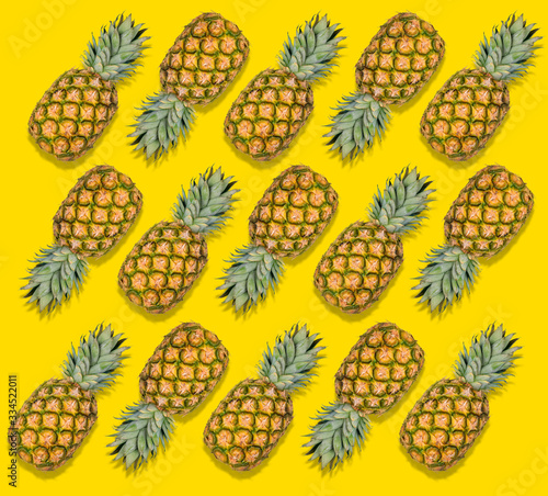Colorful fruit pattern of fresh pineapples on yellow background. Tropical abstract fruit pattern. Minimal summer food concept. Flat lay, top view