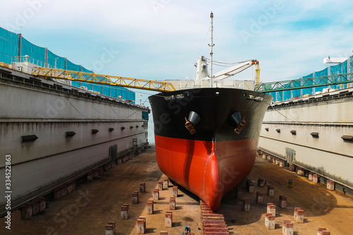 Shipyard ship repair The bulk carrier general cargo ship in dry dock yard, recondition of hull repairing and repainting, working in dry dock yard.
