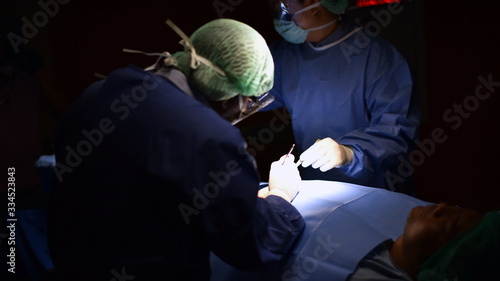 surgical instrument lying on table while group of surgeon work in operation room at hospital, emergency case, surgery, medical technology, health care cancer and disease treatment