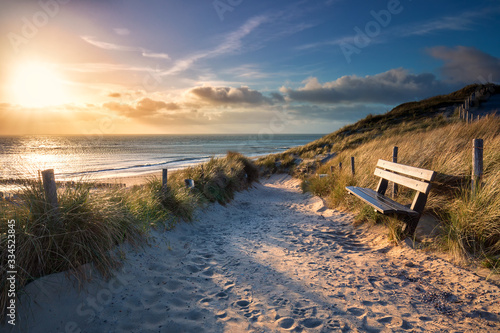 evening sunshine over bench and path to sea beach