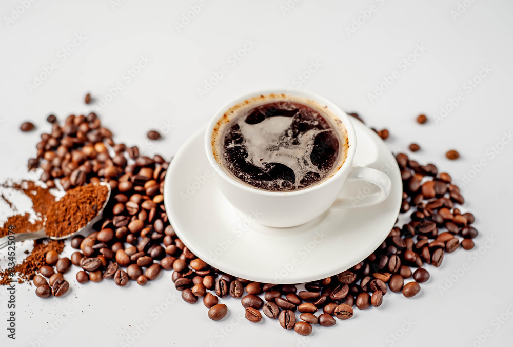 Cup of coffee and coffee beans on a white background with copy space for your text. Cup of coffee and coffee beans on a white background with copy space for your text.