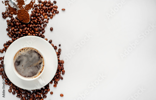 Cup of coffee and coffee beans on a white background with copy space for your text.