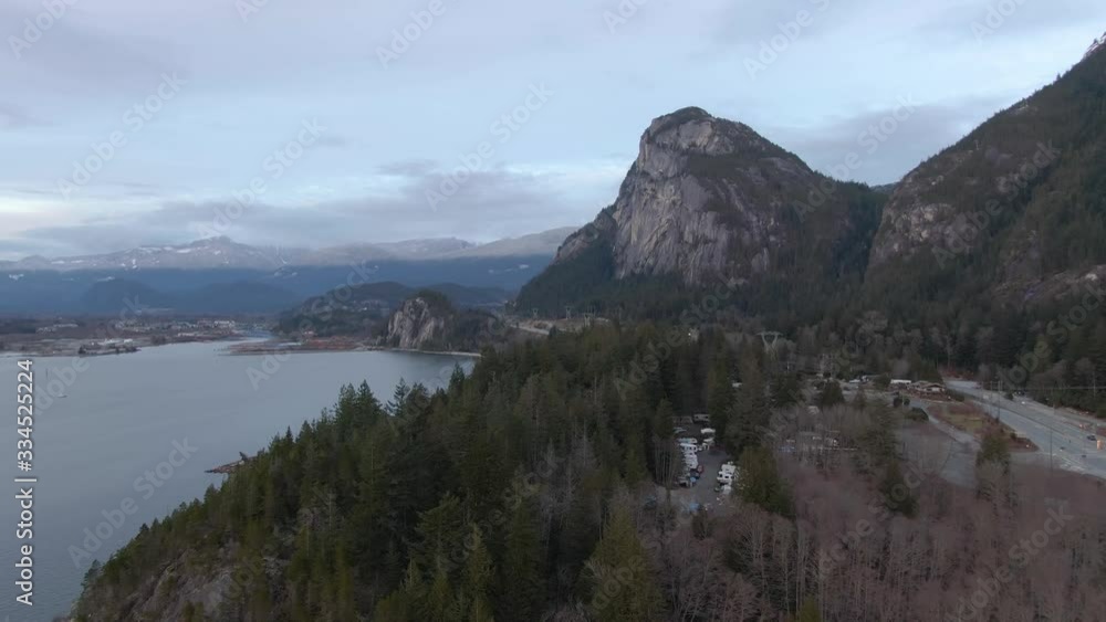 Aerial view of Sea to Sky Highway with Chief Mountain in the background during a cloudy winter sunset. Taken near Squamish, North of Vancouver, British Columbia, Canada. Aerial view of Sea to Sky Highway with Chief Mountain in the background during a cloudy winter sunset. Taken near Squamish, North of Vancouver, British Columbia, Canada.
