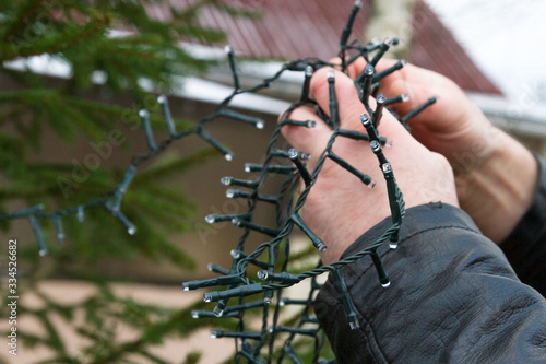 Christmas tree decoration with colorful garland on the street in winter