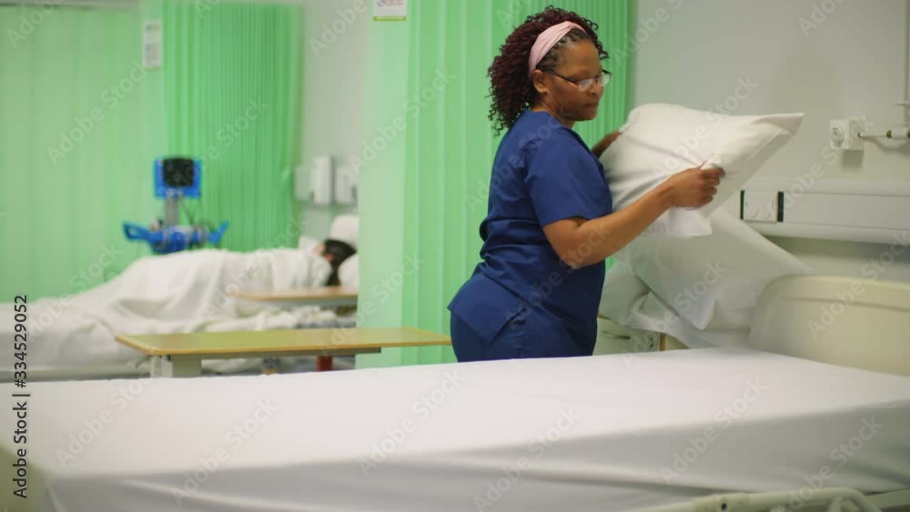 Female Nurse Making Hospital Ward Bed Female Nurse Making Hospital Ward Bed