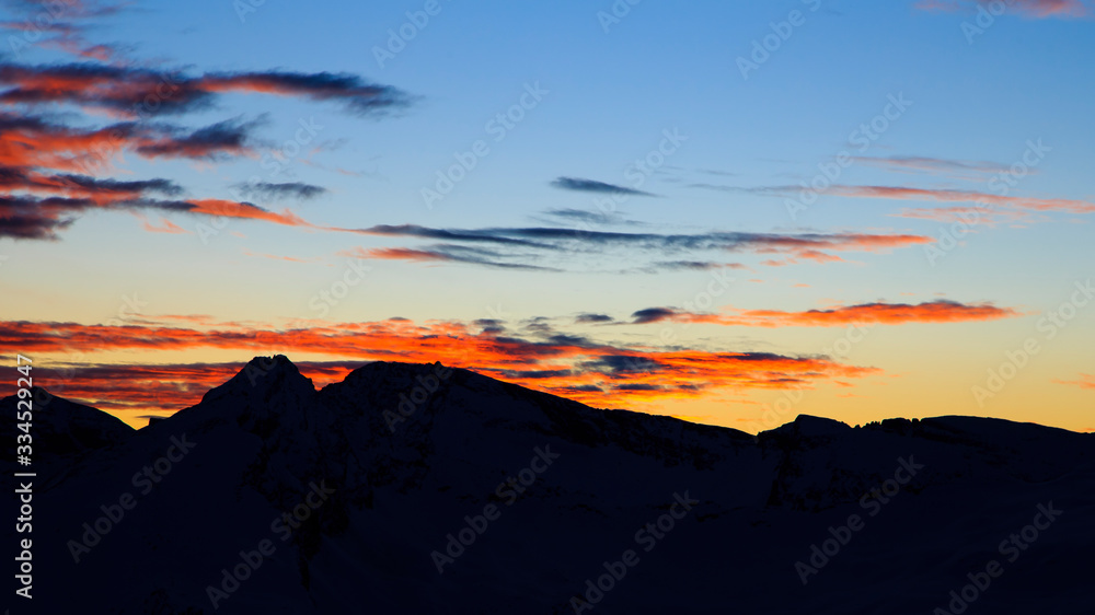 Colorful winter sunset on the top of Mons Avium Peak in Switzerland.