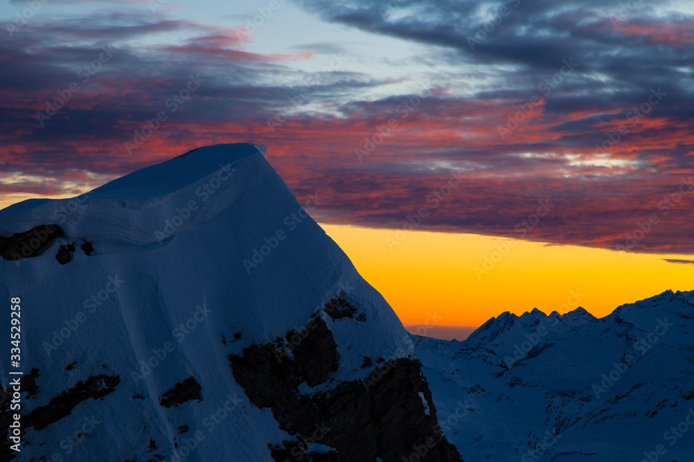 Colorful winter sunset on the top of Mons Avium Peak in Switzerland.