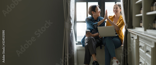 happiness asian couple male and female friend enjoy chat gossip together in coffee break asian froend use laptop smartphone casual meeting next to window home background photo