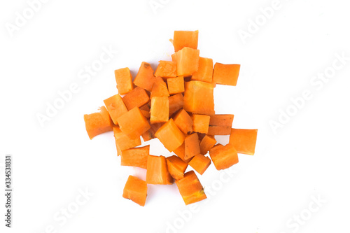 Small pieces of orange colored pumpkin pieces stacked together in a white background