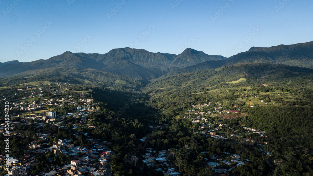 Aerial view of city in peruvian amazon jungle - forest and mountains in the background. Green area, vegetation