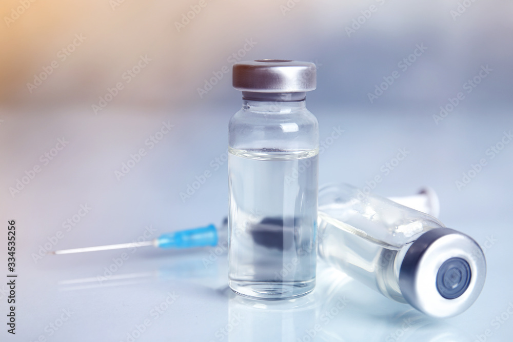 Vials and syringe on light table. Vaccination and immunization Vials and syringe on light table. Vaccination and immunization