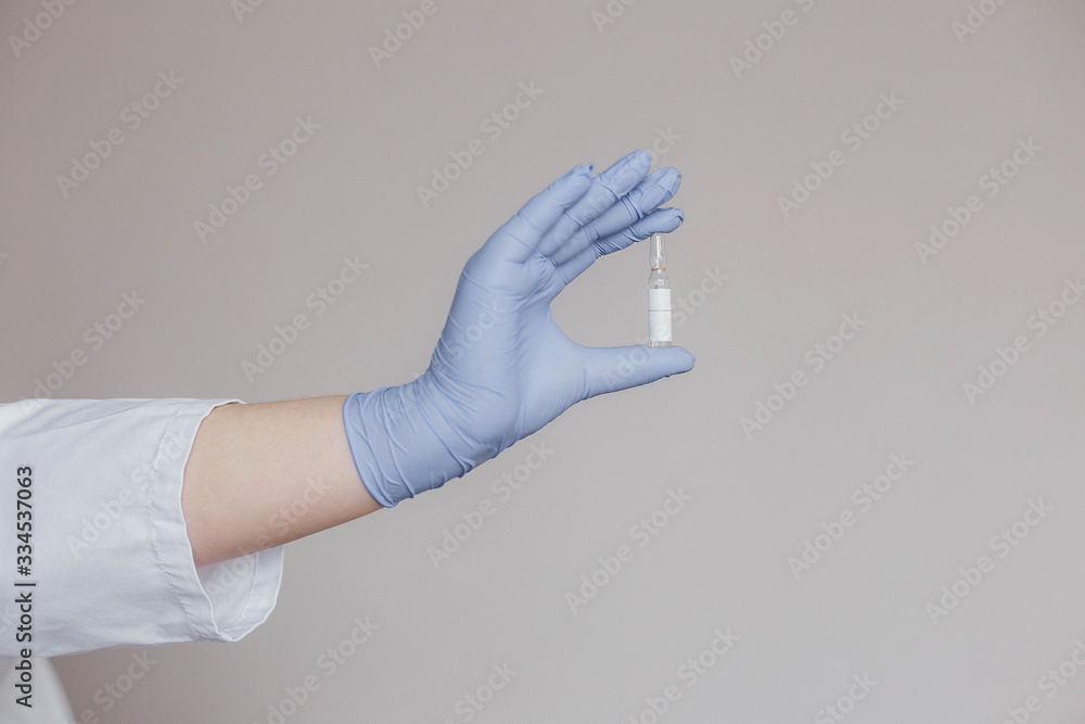 doctor in white coat and gloves holds a vaccine against the virus doctor in white coat and gloves holds a vaccine against the virus