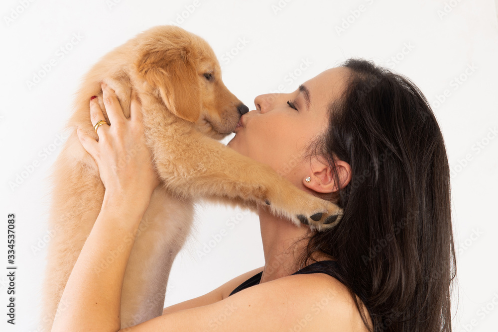 Golden Retriever puppy, with loving interaction from his female owner Golden Retriever puppy, with loving interaction from his female owner