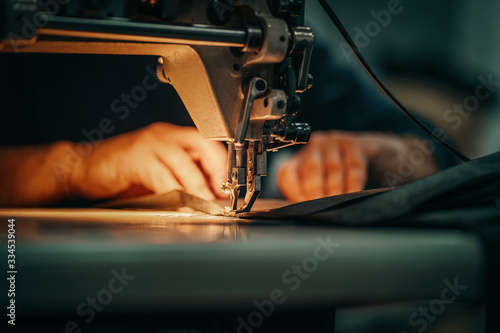Sewing machine and men's hands of a tailor photo