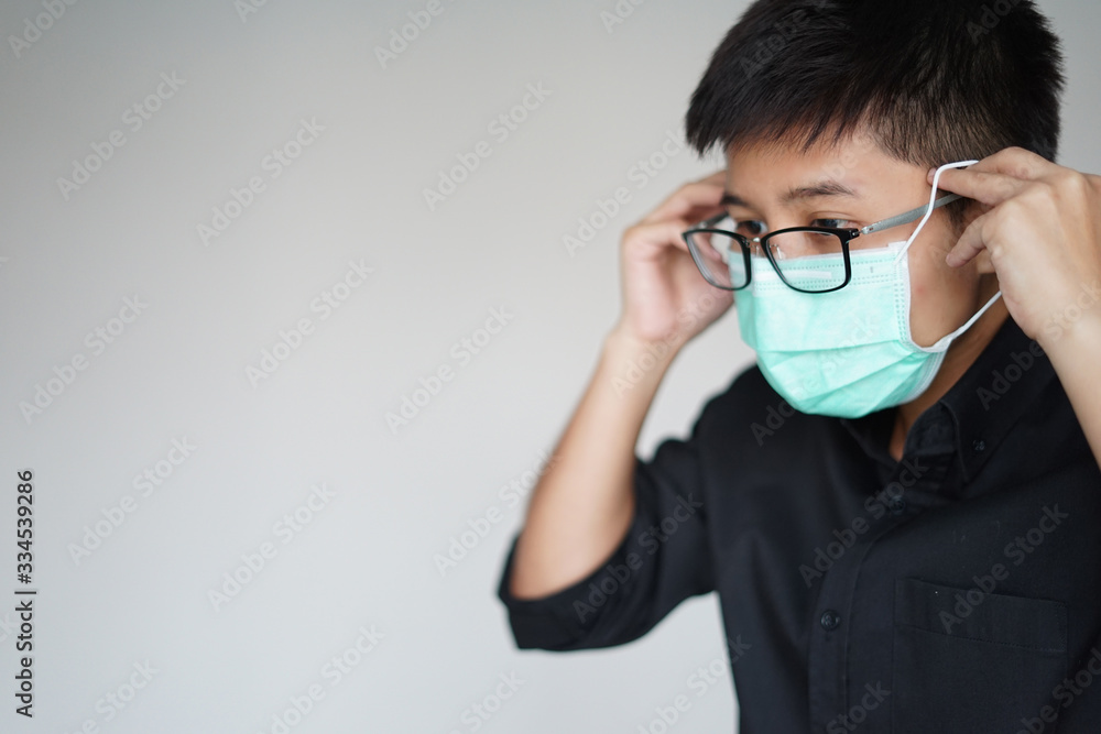 Close up the young man wearing face hygienic mask for prevention global covid-19 virus pandemic. The corona-virus from Wuhan is dangerous. People need quarantine. Close up the young man wearing face hygienic mask for prevention global covid-19 virus pandemic. The corona-virus from Wuhan is dangerous. People need quarantine.