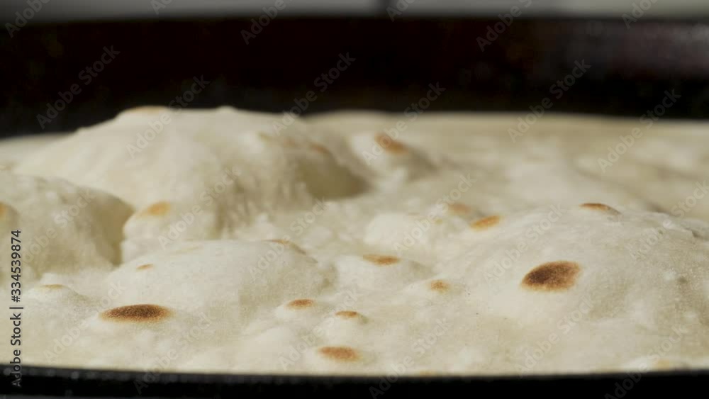 Traditional pita bread inflates with the bubble on the pan Traditional pita bread inflates with the bubble on the pan