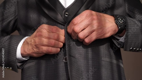 Young man buttoning buttons in his jacket. Young businessman