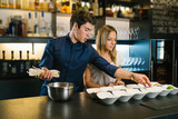 Young chef couple cooking in a modern restaurant