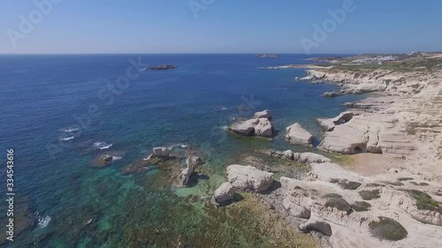 Still aerial view on waves and white limestone rocks and cliffs in blue bay of Mediterranean sea. Paphos sea caves suburbs, Cyprus photo