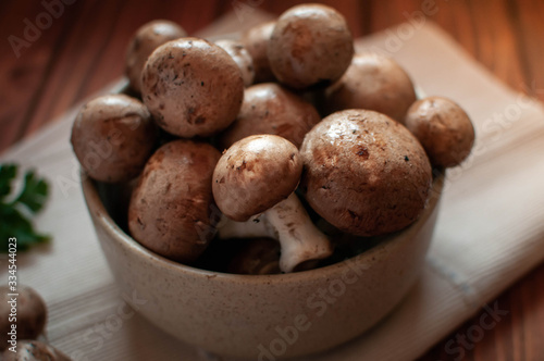 Close-up of brown mushrooms in a bowl, on wooden table