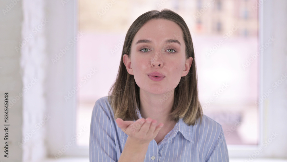 Fototapeta premium Portrait of Attractive Young Woman Giving Flying Kiss