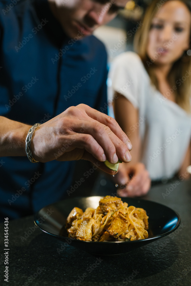 Young chef couple cooking noodle in a kitchen in a modern restaurant