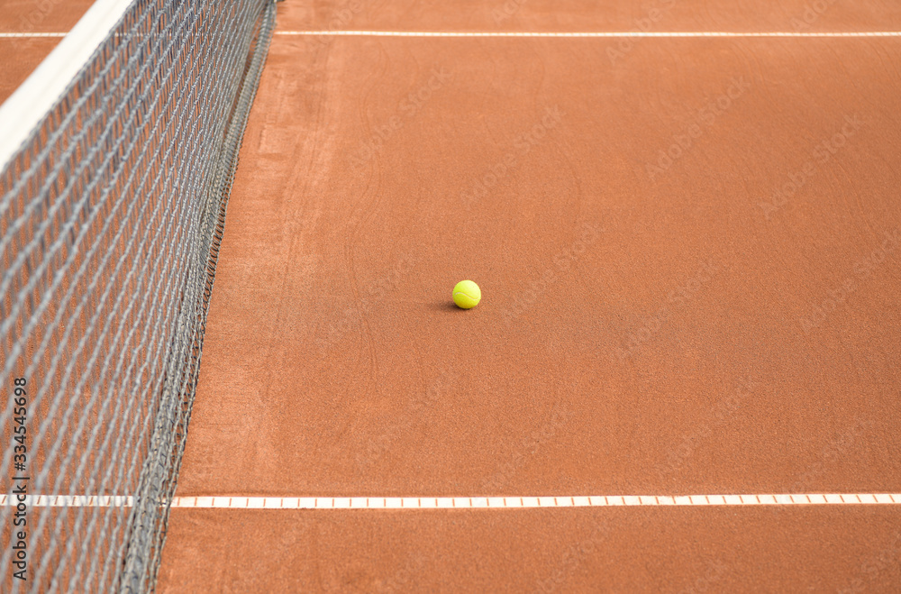 Tennis ball between horizontal lines and near the net on a clay tennis court