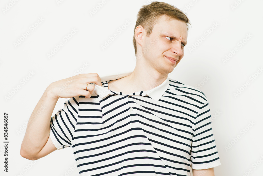 Closeup portrait of young man opening shirt to vent,it's hot. Negative emotion, facial expression, feeling Closeup portrait of young man opening shirt to vent,it's hot. Negative emotion, facial expression, feeling