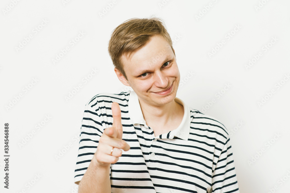 Young man showing his index finger towards the camera Young man showing his index finger towards the camera
