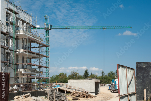 Crane and scaffolding on the construction area of new residential building.