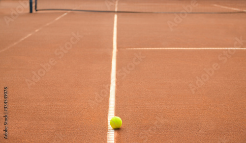 Tennis ball on a line on a lonely clay tennis court. No match. © NomadCam