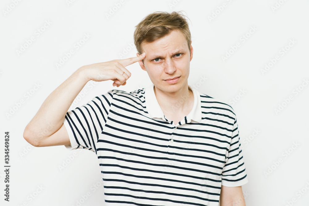 Closeup portrait of angry man gesturing with his finger against his temple, are you crazy? Closeup portrait of angry man gesturing with his finger against his temple, are you crazy?