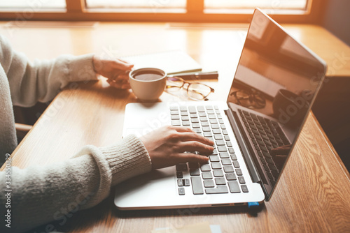 Young woman working in a home office on her laptop computer. Remote work concept. photo