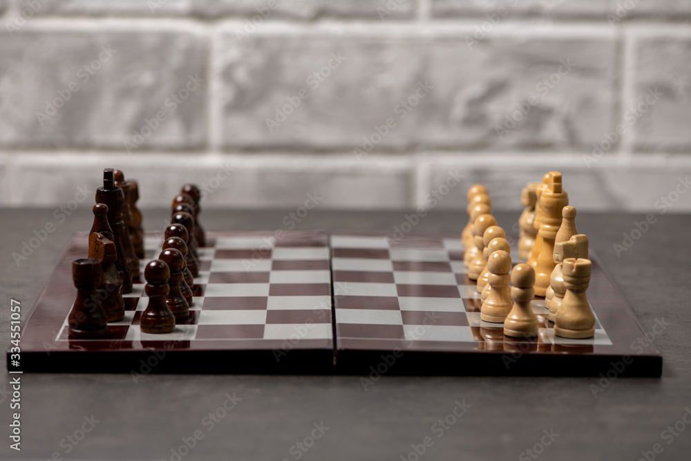 chess board with figures stands on gray cement background chess board with figures stands on gray cement background