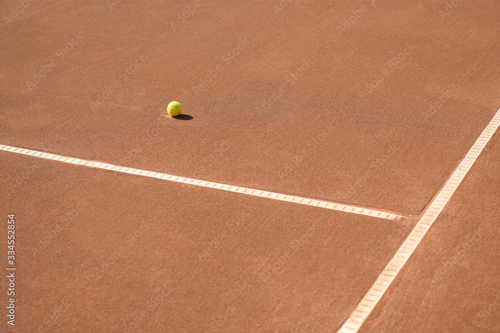 Lonely ball near the lines on a clay tennis court