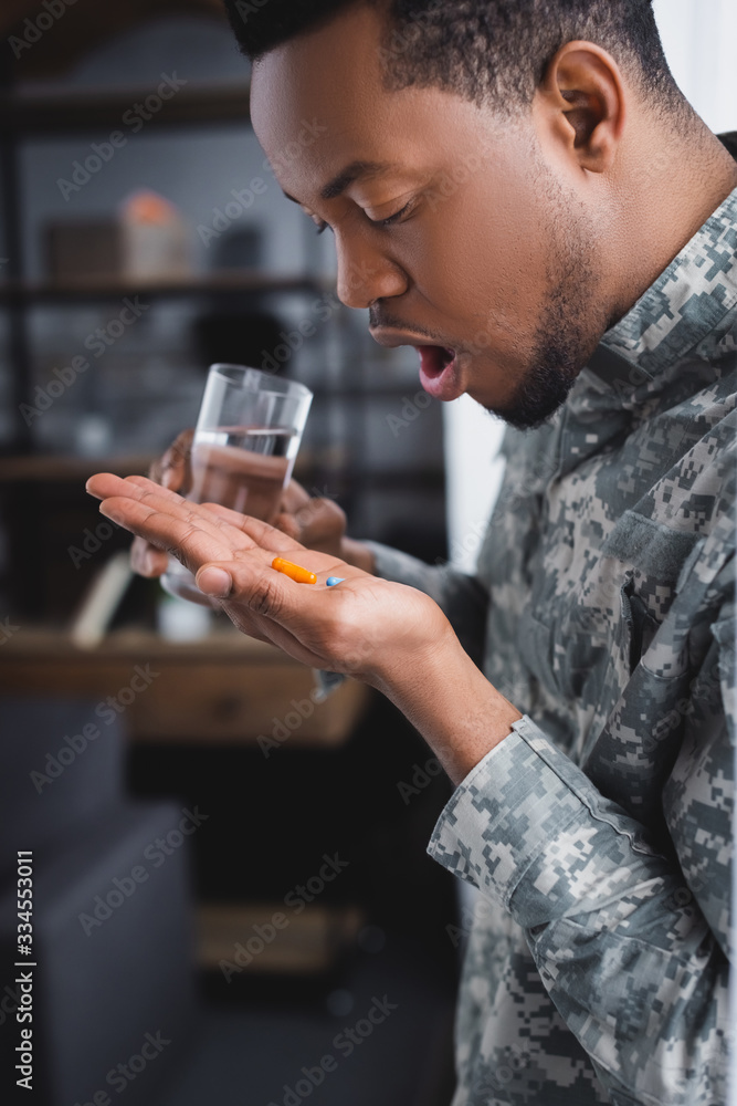 african american soldier taking pills and suffering from PTSD at home african american soldier taking pills and suffering from PTSD at home