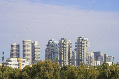 Silhouette view of the city's old and new buildings. Blue cloudy sky in the background. Panorama of expensive residential complexes in the center of Tel Aviv. Israel.