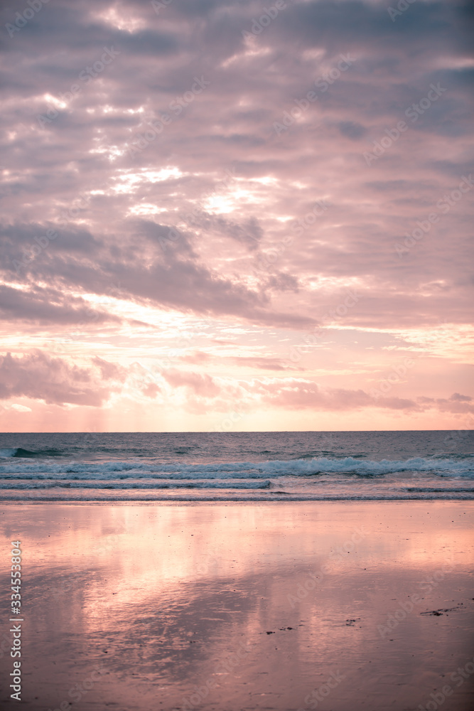Pink and Blue: Cloudy Sky and Ocean with their Reflection on Wet Sands
