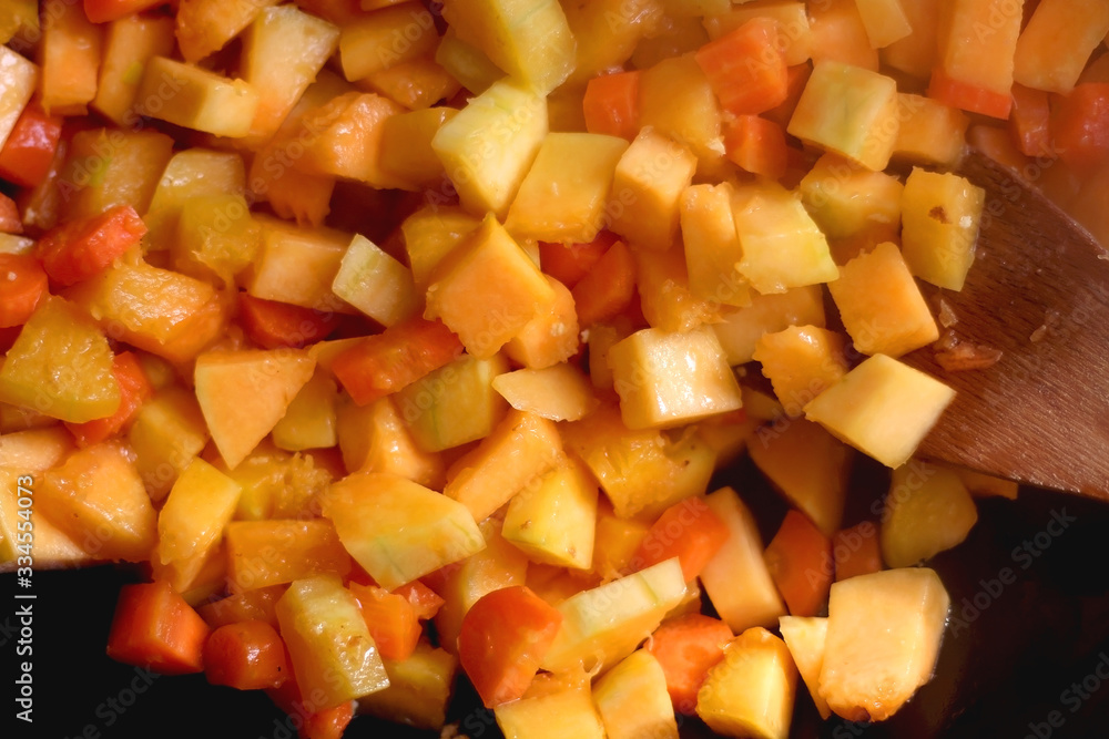 Chopped carrots and butternut squash in a wok. Top view. Chopped carrots and butternut squash in a wok. Top view.