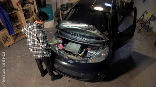Man is repairing car engine in the garage