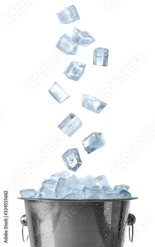 Ice cubes falling into bucket on white background